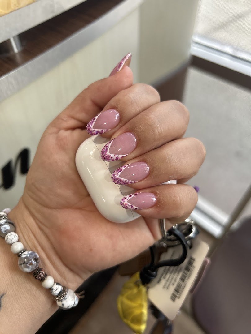 Hands receiving a detailed nail treatment.