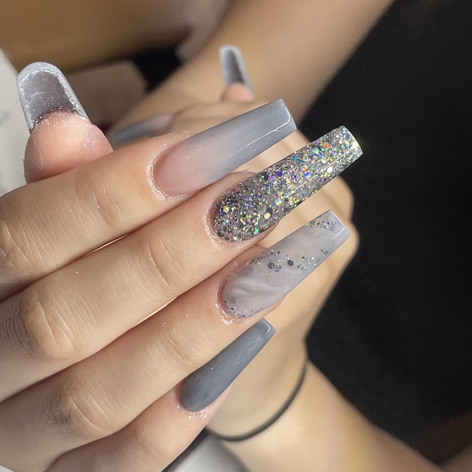 Hands receiving a detailed nail treatment.
